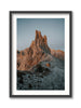 A framed print depicting the Vajolet Towers mountain range in the Dolomites, with a hiker setting up a tent in the foreground.