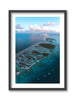 Framed aerial view of a tropical island with clear blue water and white clouds, featuring French Polynesia