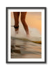 Framed artwork of a person's feet walking on a beach with a blurred background, film like image